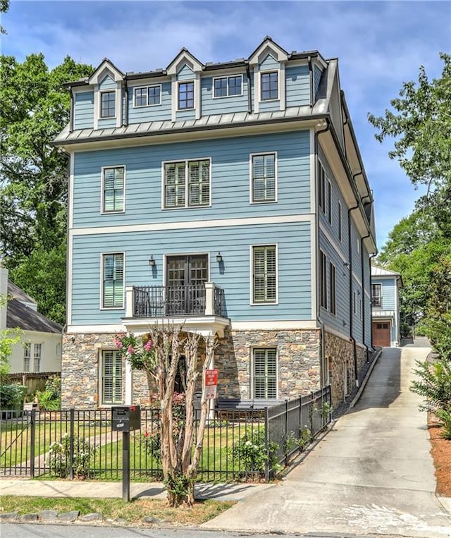 2972 Lookout Pl NE, Atlanta, GA 30305 - view of front facade featuring stone siding, a standing seam roof, a metal roof, a fenced front yard, and a balcony