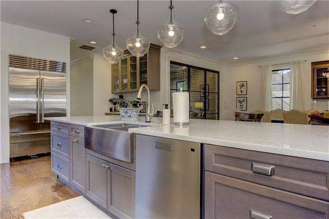 2972 Lookout Pl NE, Atlanta, GA 30305 - kitchen featuring stainless steel appliances, wood finished floors, glass insert cabinets, recessed lighting, and decorative light fixtures