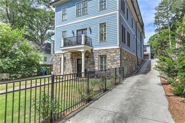 2972 Lookout Pl NE, Atlanta, GA 30305 - view of front of home with a balcony, a fenced front yard, and stone siding
