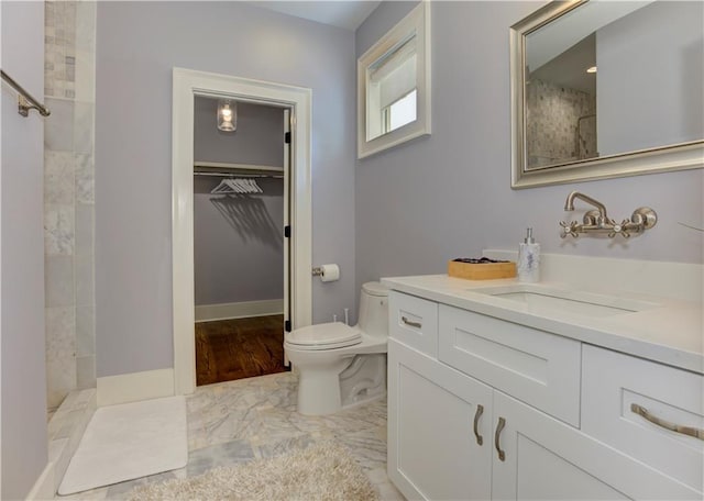 2972 Lookout Pl NE, Atlanta, GA 30305 - bathroom with vanity, tiled shower, a walk in closet, and marble look tiles