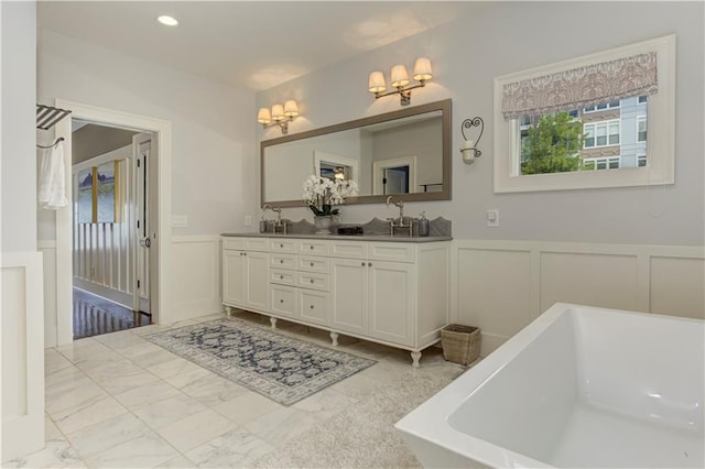 2972 Lookout Pl NE, Atlanta, GA 30305 - bathroom with a decorative wall, a freestanding bath, double vanity, and wainscoting