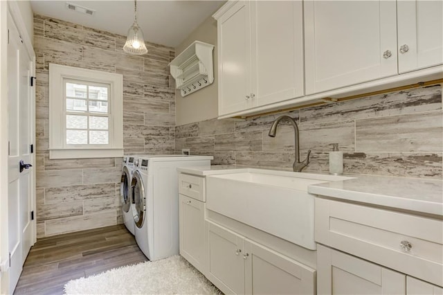 2972 Lookout Pl NE, Atlanta, GA 30305 - washroom featuring cabinet space, washer and clothes dryer, tile walls, and light wood-type flooring