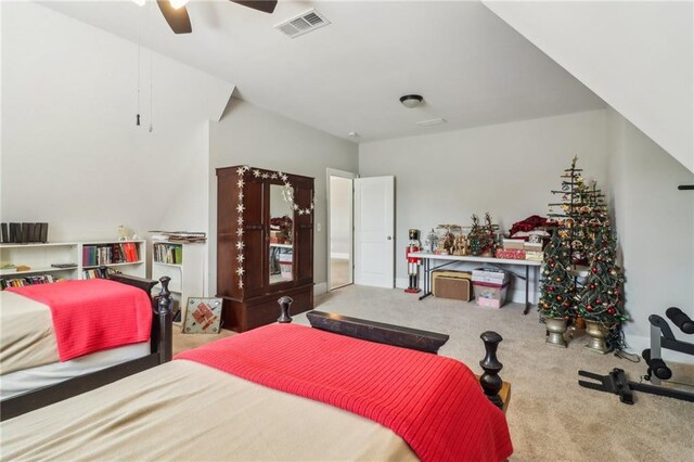 bedroom with visible vents, light colored carpet, baseboards, and ceiling fan