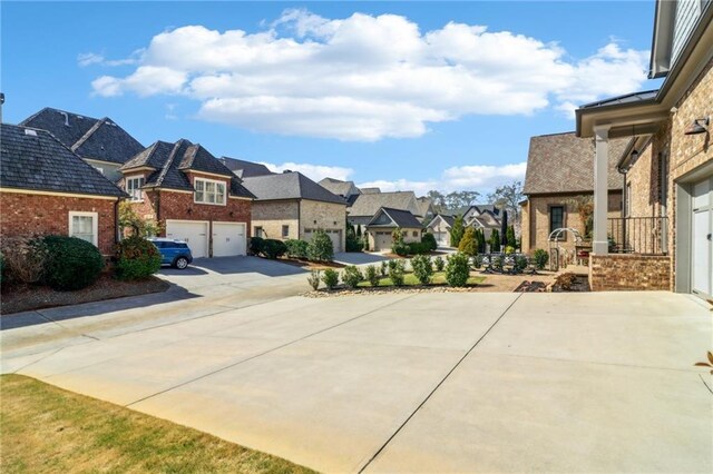 view of front of home featuring brick siding, a garage, driveway, and a front yard