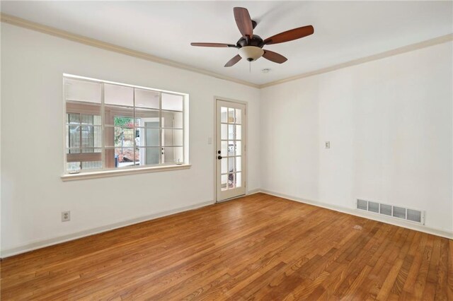 empty room featuring wood-type flooring, ceiling fan, and ornamental molding