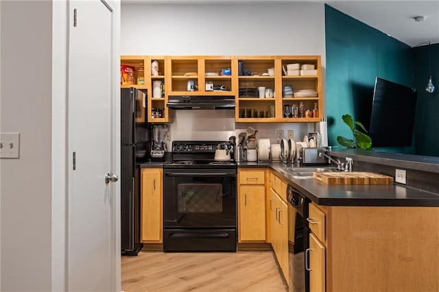 kitchen featuring under cabinet range hood, light wood finished floors, a sink, black appliances, and dark countertops