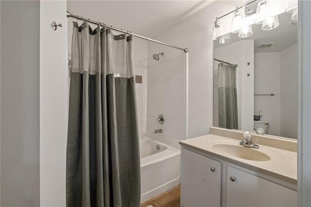 full bathroom featuring vanity, shower / bathtub combination with curtain, and visible vents