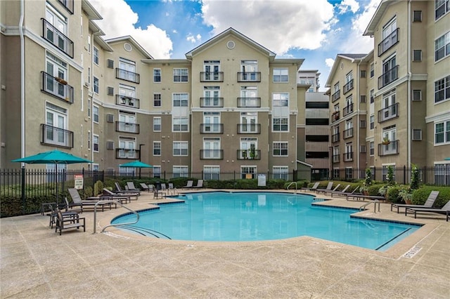 community pool featuring a patio and fence