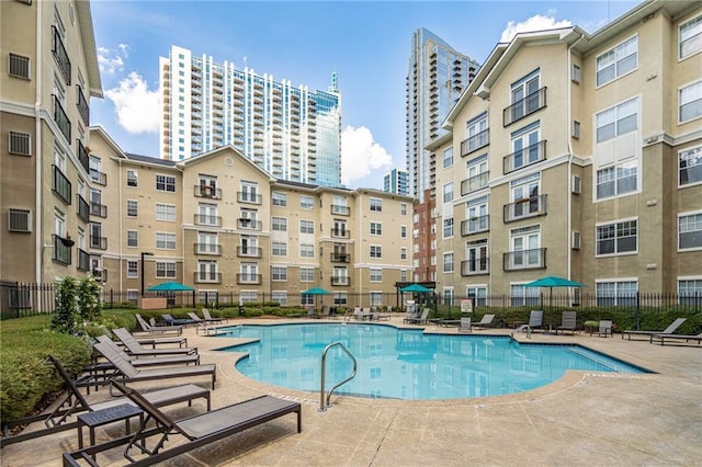 community pool with fence and a patio area