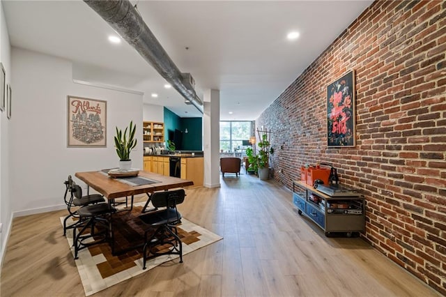 dining space featuring baseboards, recessed lighting, brick wall, and light wood-type flooring
