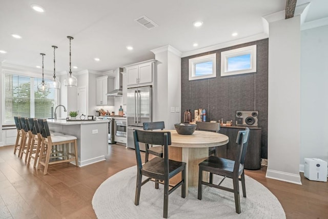 5217 Riden Ct Unit 263, Buford, GA 30518 - dining space with ornamental molding, dark wood finished floors, an accent wall, recessed lighting, and baseboards