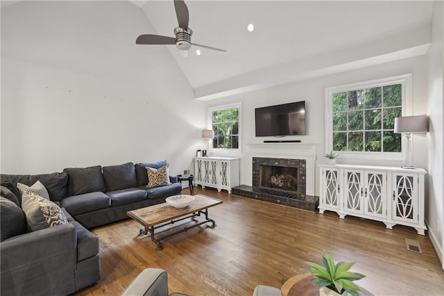 living area featuring a ceiling fan, lofted ceiling, wood finished floors, a tile fireplace, and recessed lighting