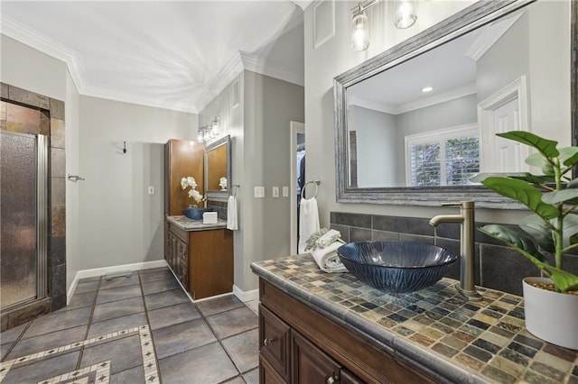 full bathroom with a stall shower, crown molding, baseboards, and two vanities