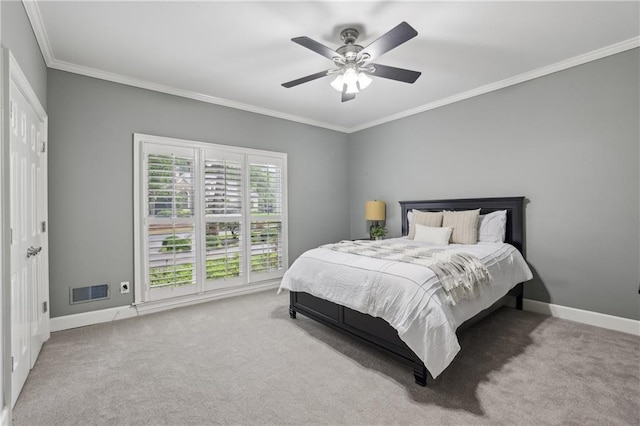 carpeted bedroom featuring ornamental molding, baseboards, and ceiling fan