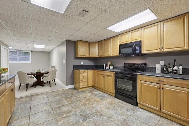 kitchen with black appliances, a paneled ceiling, dark countertops, and baseboards