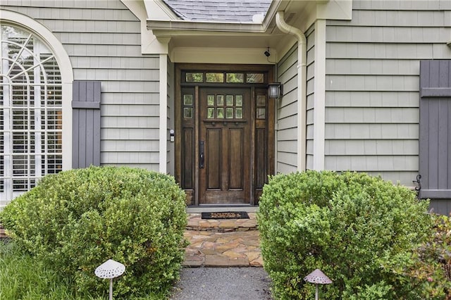 doorway to property featuring a shingled roof