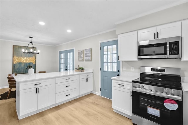 kitchen featuring a peninsula, white cabinetry, stainless steel appliances, and light countertops