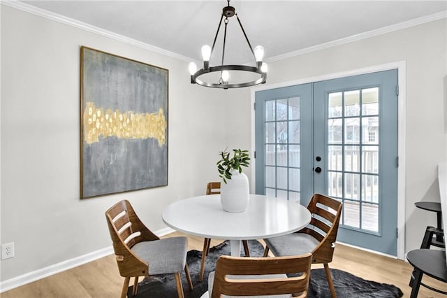 dining room featuring ornamental molding, light wood-type flooring, french doors, and baseboards