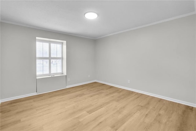 unfurnished room featuring light wood-type flooring, crown molding, and baseboards