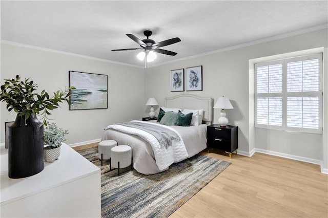 bedroom with baseboards, a ceiling fan, light wood-style flooring, and crown molding