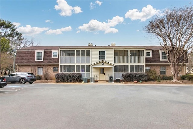 view of property with uncovered parking and central AC unit