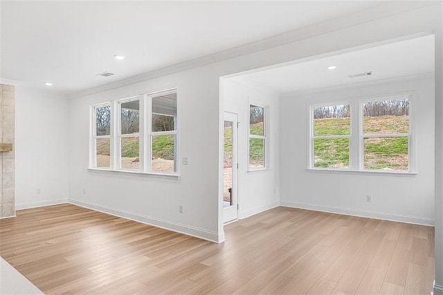 unfurnished living room featuring crown molding and light hardwood / wood-style floors