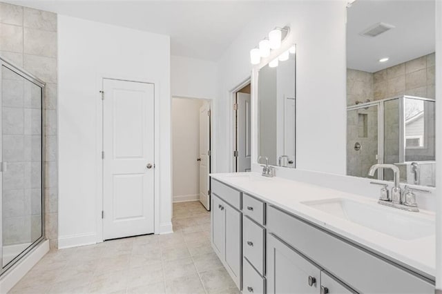 bathroom with an enclosed shower, vanity, and tile patterned floors