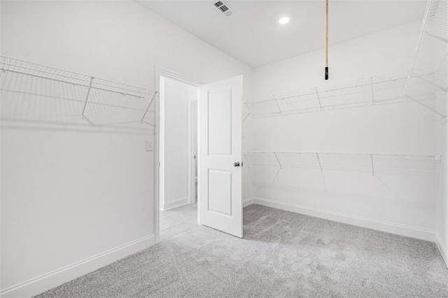 spacious closet featuring light colored carpet