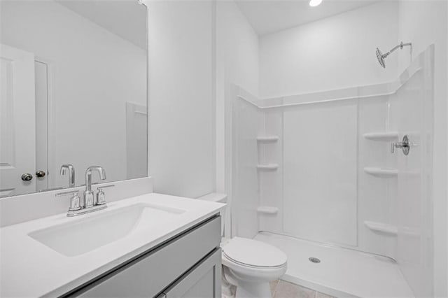 bathroom featuring tile patterned flooring, walk in shower, vanity, and toilet