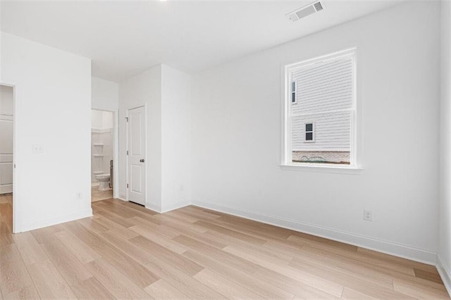 unfurnished bedroom featuring connected bathroom and light hardwood / wood-style flooring