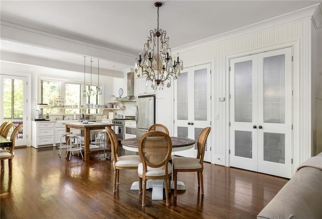 dining room with french doors, a notable chandelier, dark wood-style floors, and crown molding