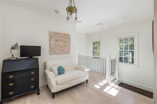 living area featuring baseboards, an upstairs landing, wood finished floors, and crown molding