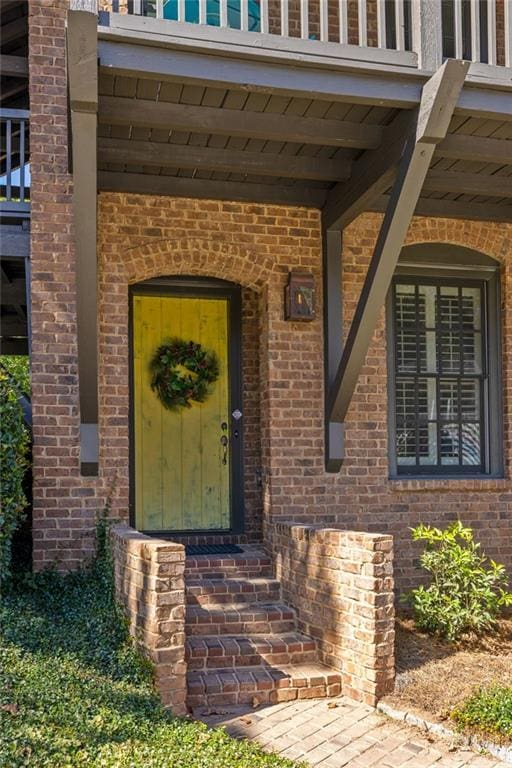 view of exterior entry with brick siding