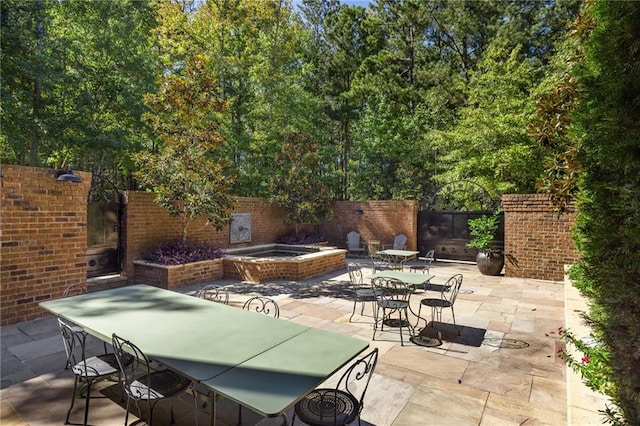 view of patio featuring outdoor dining area, an outdoor hot tub, and a fenced backyard
