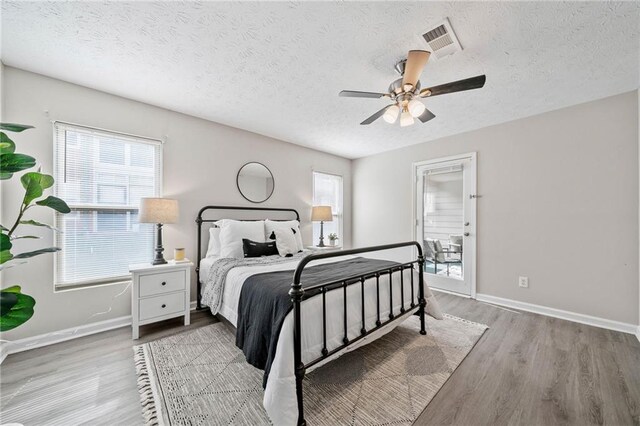 705 Beaufort Cir, Duluth, GA 30096 - bedroom featuring wood finished floors, a textured ceiling, baseboards, and a ceiling fan