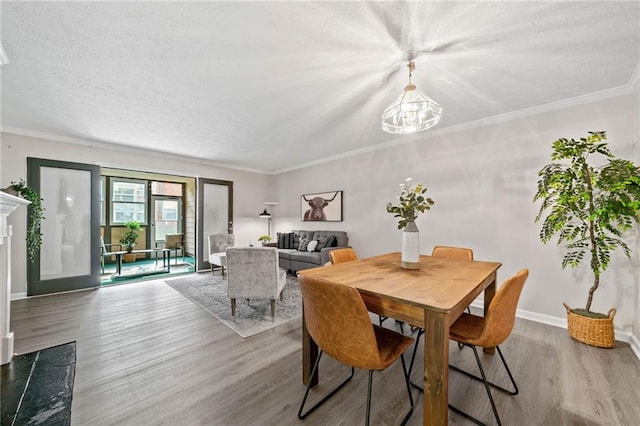 705 Beaufort Cir, Duluth, GA 30096 - dining area featuring wood finished floors, a chandelier, baseboards, crown molding, and a textured ceiling