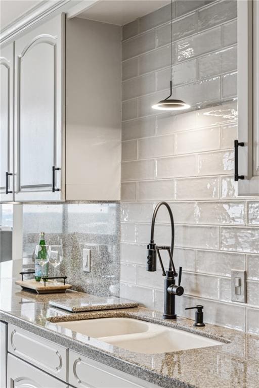 2660 Peachtree Rd NW Unit 23A, Atlanta, GA 30305 - kitchen with decorative backsplash, white cabinetry, and light stone countertops