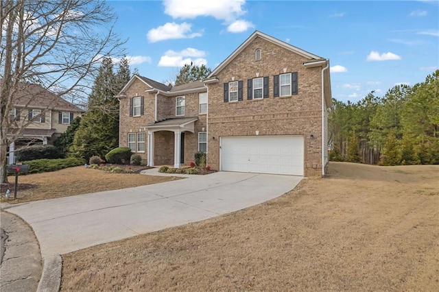 traditional home with concrete driveway, a front lawn, an attached garage, and brick siding