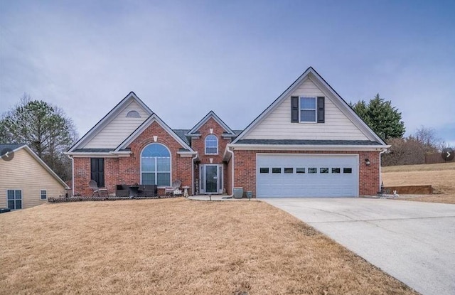 view of front of property featuring brick siding, driveway, an attached garage, and a front yard