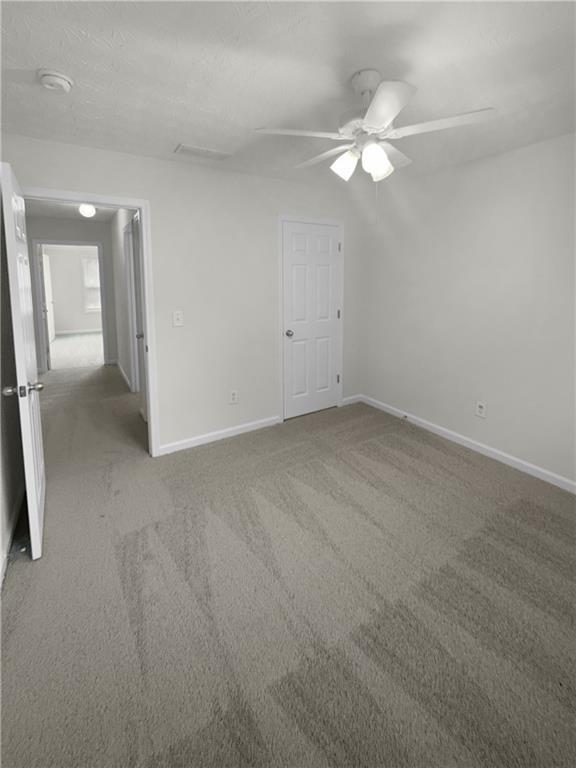 unfurnished bedroom with ceiling fan and carpet flooring