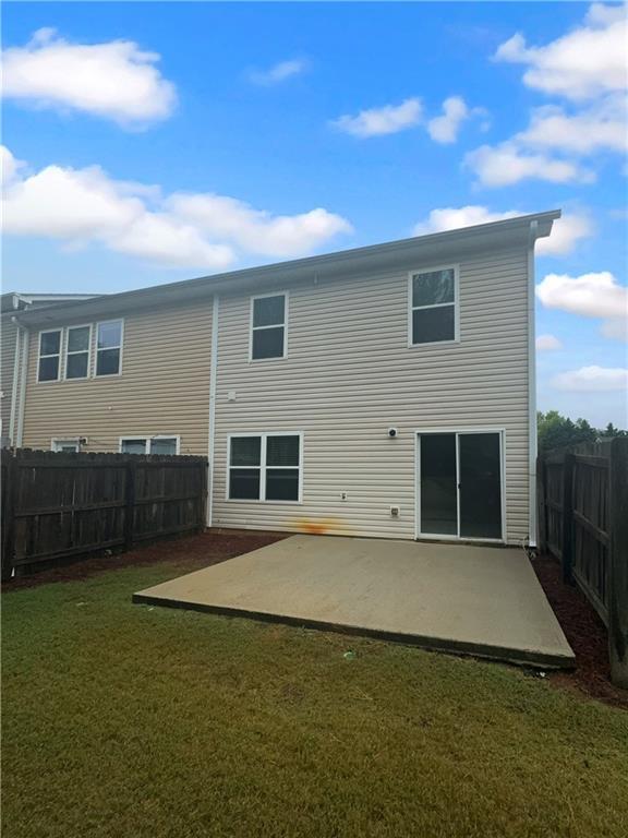 back of house with a yard and a patio