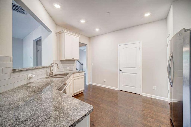 kitchen with appliances with stainless steel finishes, tasteful backsplash, white cabinets, and sink