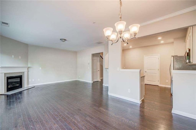 unfurnished living room featuring dark wood-type flooring, a notable chandelier, and ornamental molding