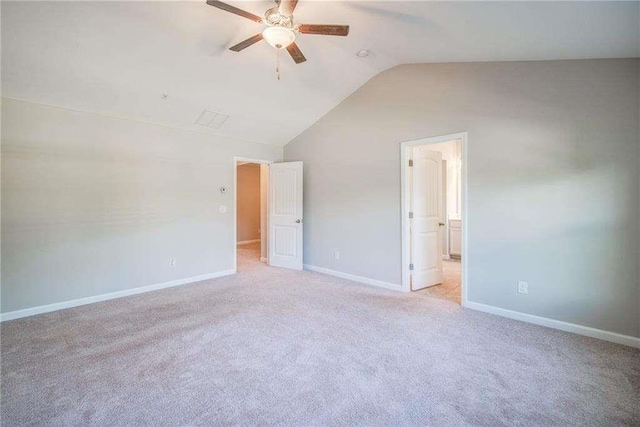 interior space featuring ceiling fan, vaulted ceiling, and light carpet