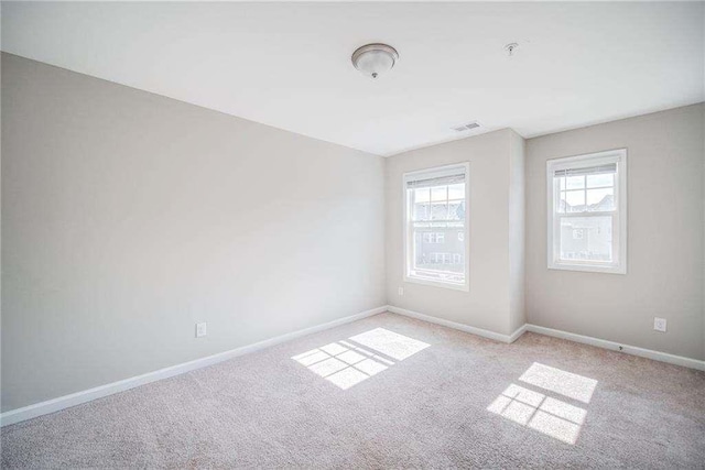 spare room featuring light colored carpet