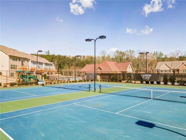 view of sport court featuring basketball hoop and a playground