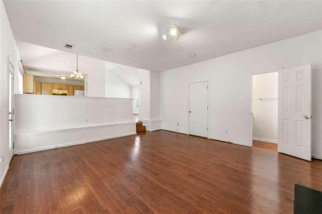 empty room with wood-type flooring and a chandelier