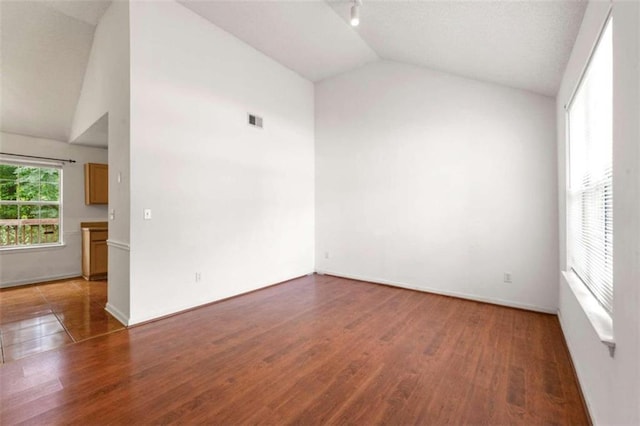 empty room featuring dark hardwood / wood-style flooring and high vaulted ceiling