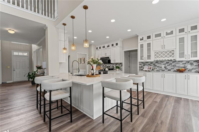 479 Rising Sun Path, Lawrenceville, GA 30043 - kitchen featuring a breakfast bar, backsplash, light wood-style flooring, white cabinetry, and recessed lighting