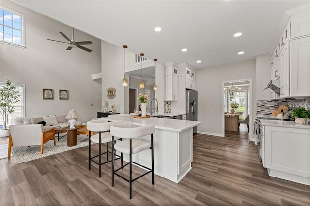 479 Rising Sun Path, Lawrenceville, GA 30043 - kitchen featuring a peninsula, open floor plan, tasteful backsplash, light countertops, and stainless steel fridge with ice dispenser
